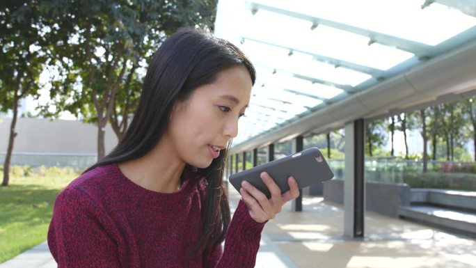 一名女子在户外用手机通话