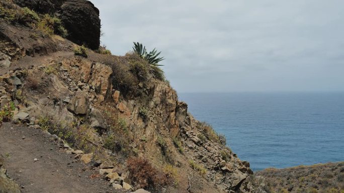 一名妇女在特内里费岛的海岸风景中徒步旅行
