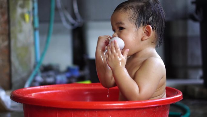 一个刚出生的婴儿在盆里的水中玩耍