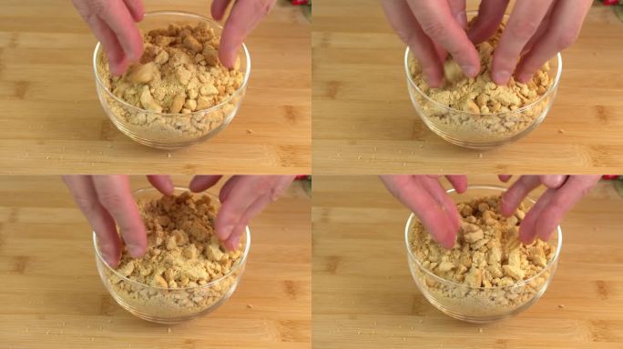 手把碎饼干放在碗里，放在木头砧板上，准备做甜点。茶点脆饼