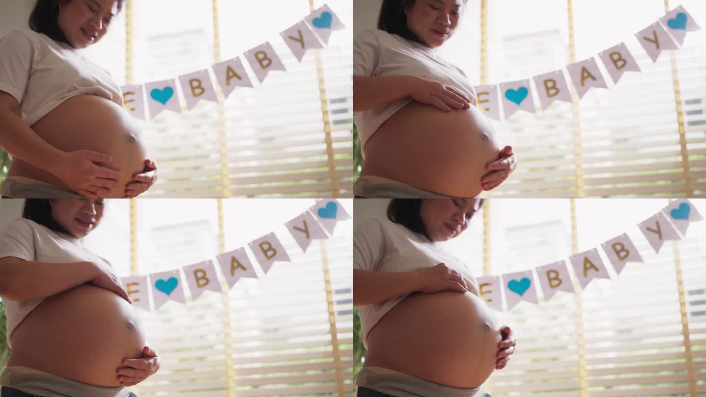 微笑开朗的亚洲孕妇在她的腹部涂抹保湿护肤霜,孕妇按摩她的腹部涂抹霜防止妊娠纹,妇女在腹部涂抹保湿霜