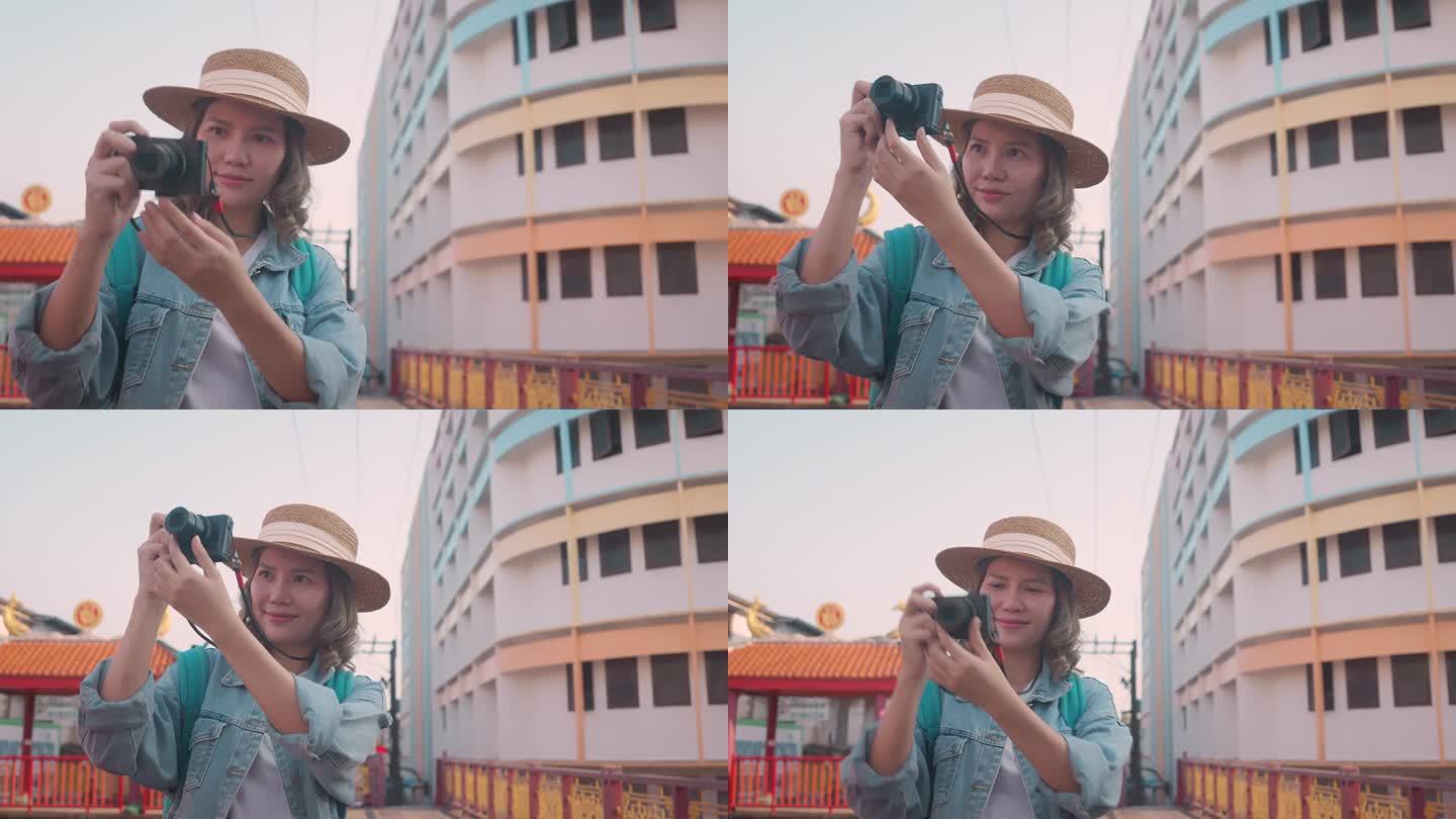 年轻的亚洲女性背包旅行者在城市中使用相机。旅行的生活方式。世界旅游探索者或亚洲夏季旅游概念。