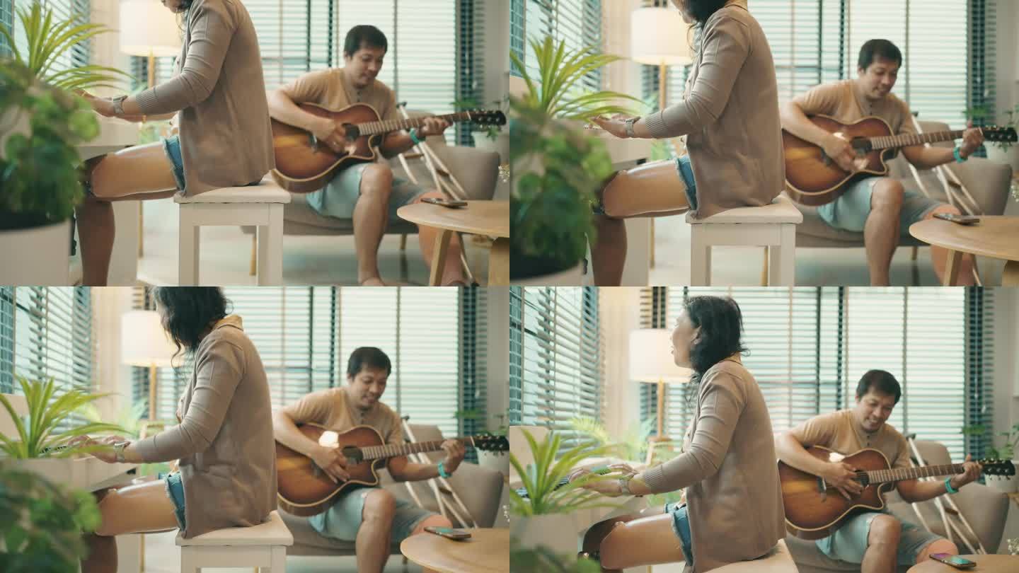 迷人的亚洲残疾夫妇在家里一起弹吉他和钢琴。冷静的态度。积极情绪。残疾人。