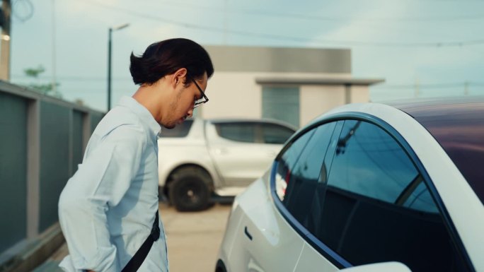 年轻的亚洲男人用你的智能手机解锁你的车