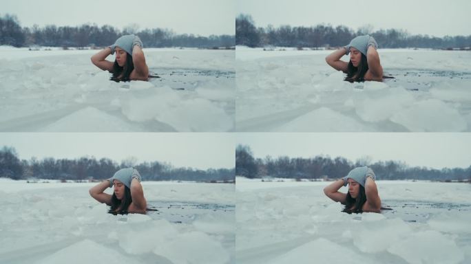 女人在冰天雪地里冬泳。淹没在冰冷的水中
