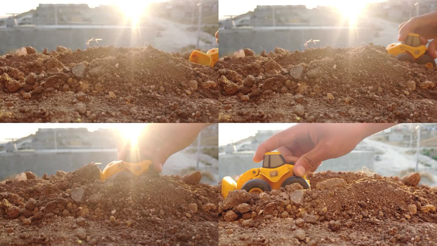 在阳光下在地上玩玩具挖掘机