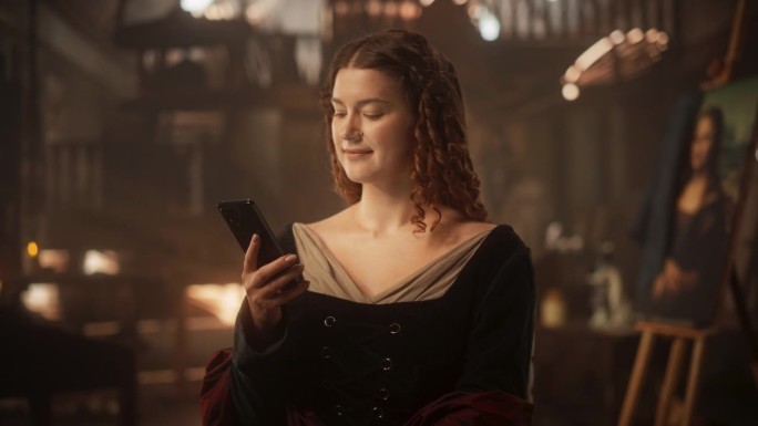 创新理念:身着中世纪服饰的美丽女性在室内使用智能手机。给朋友发短信，在社交媒体上发帖，用电子商务进行