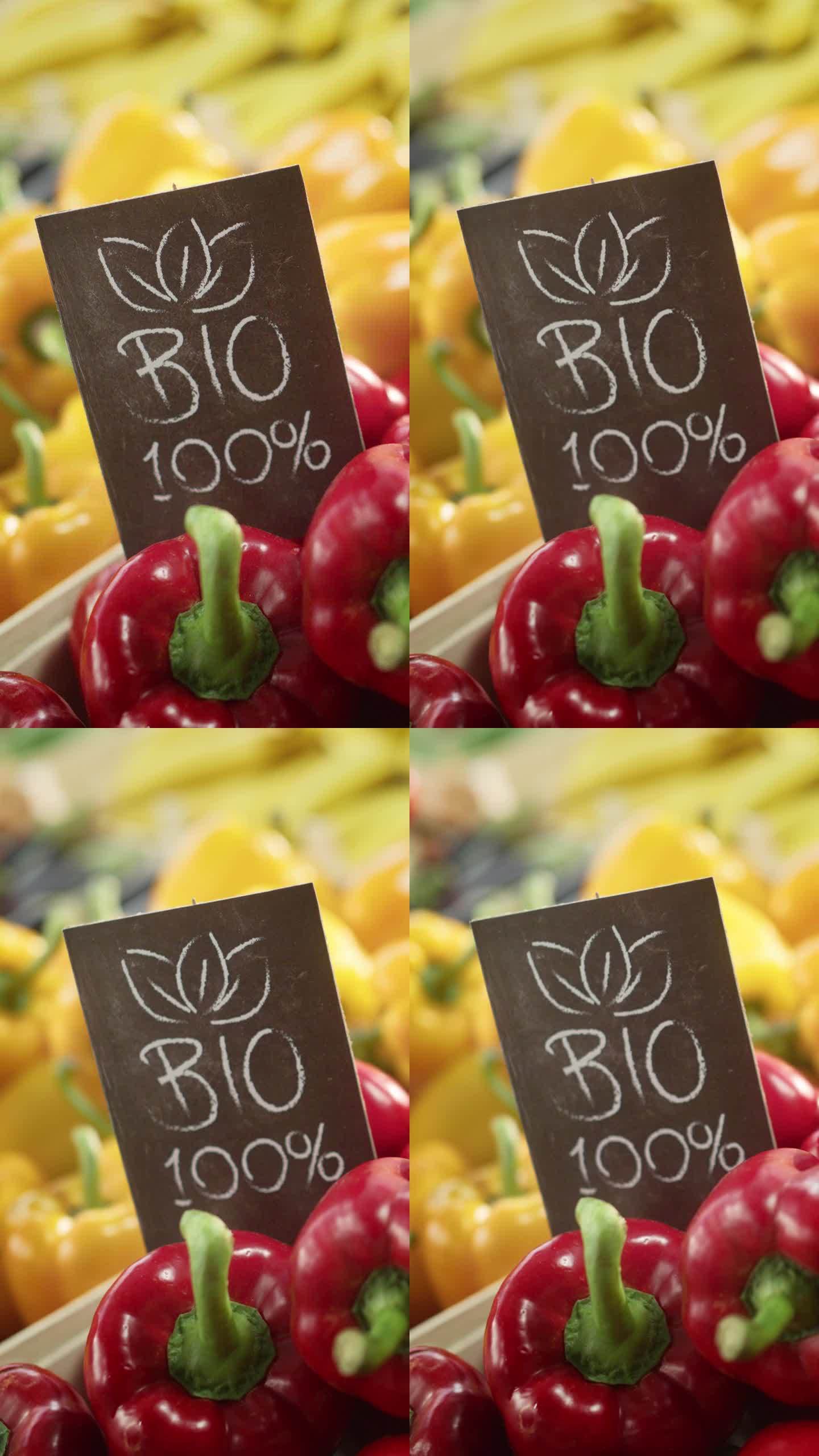 垂直屏幕:100%生物标志食品摊上新鲜的红和黄色有机甜椒来自当地农场。户外农贸市场的有机水果和蔬菜没