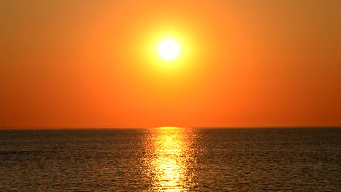 美丽的日落黎明在海上。日出，日落，黎明。太阳升起。阳光明媚，阳光灿烂。海水起伏，水面泛起涟漪。阳光路