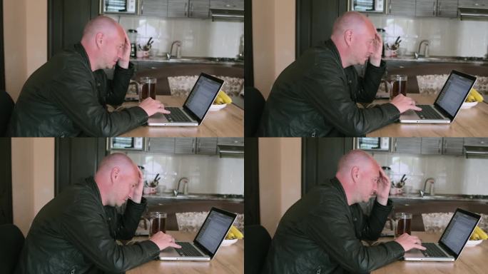 成年白人男子晚上端着一杯啤酒坐在笔记本电脑前，盯着显示器