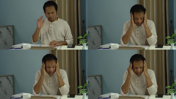 在家工作的亚洲男性因工作时间过长而头痛。办公室综合症。