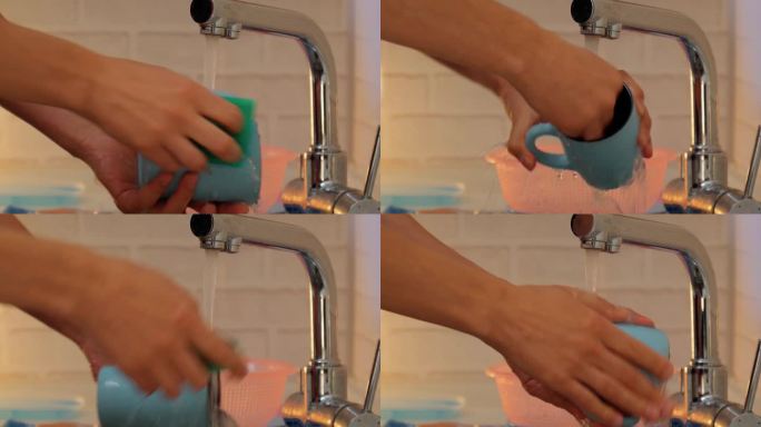 在厨房里，男人一边用清洁垫、肥皂和水擦盘子，一边用双手。