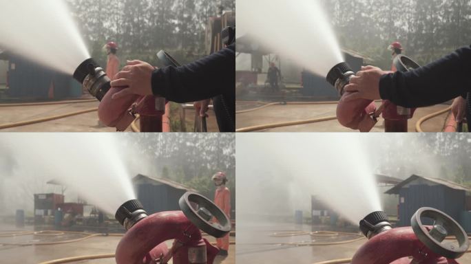 消防队员使用灭火器和软管中的水灭火。