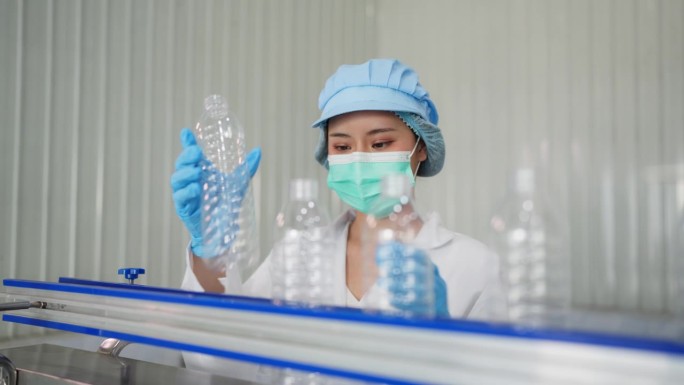 随着生产设备的启动，生产线开始活跃起来，员工穿着实验室工作服，熟练地拿起瓶子，放在灌装线上的自动传送