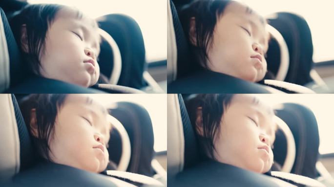 与家人一起旅行时，一个亚洲小孩在汽车座椅上休息