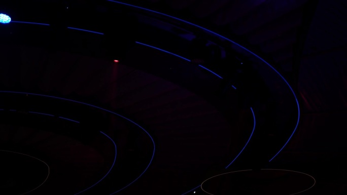 抽象背景闪烁舞台灯光音乐会迪斯科灯光。明亮闪亮的舞台灯光在黑暗中闪烁着娱乐运动，蓝色柔和的灯光打在聚