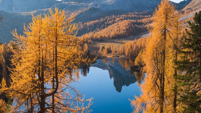 在晴朗的秋日早晨，从多洛米蒂一个平静的山湖上俯瞰