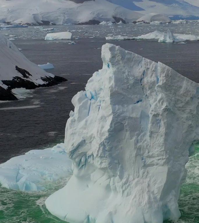 垂直视频巨大的冰山拱，雪山在南极海洋。