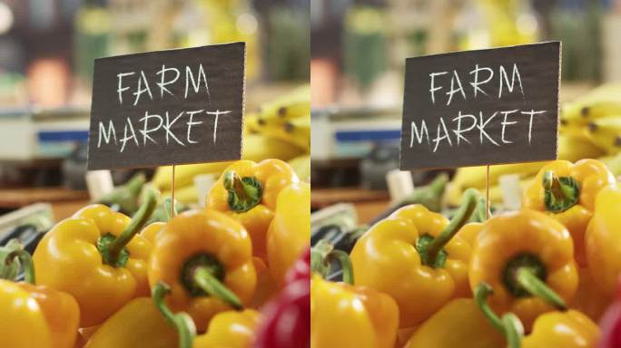 竖屏:农贸市场生态蔬果大排档。有机红色和黄色灯笼椒，新鲜茄子，生物香蕉和其他杂货在户外摊位上的标志