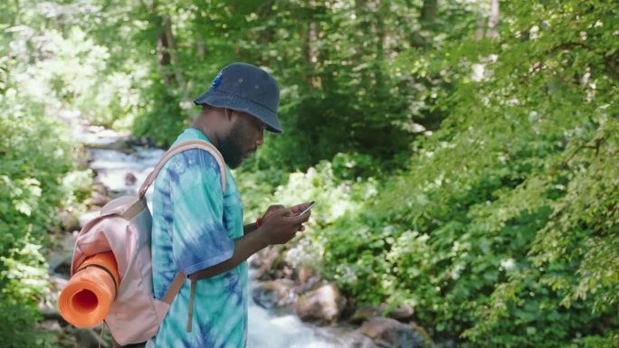 一名徒步旅行者在森林里用智能手机寻找路线。