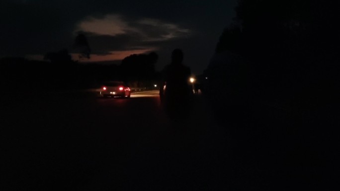 漆黑的夜晚在公路上行走的情侣夜晚公路车流