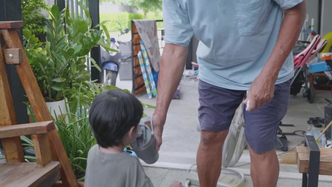 亚洲老人沏菊花水，和他的孙子开心地跳舞。