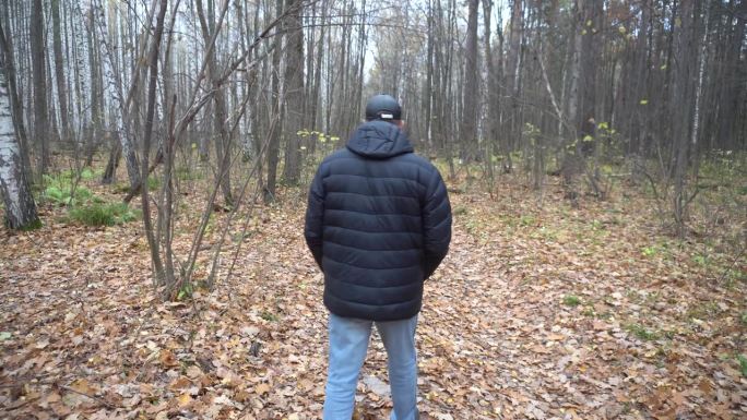 一个50岁的男人走在秋天的森林里，文字说