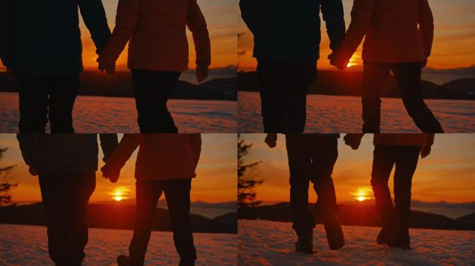 一对无法辨认的老年夫妇在黄金时间牵着手走在雪地里