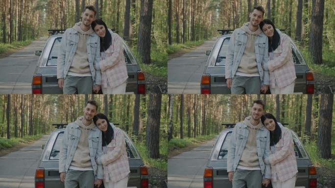一对幸福的夫妇站在森林里，旁边是汽车，他们从农村的公路旅行中放松下来