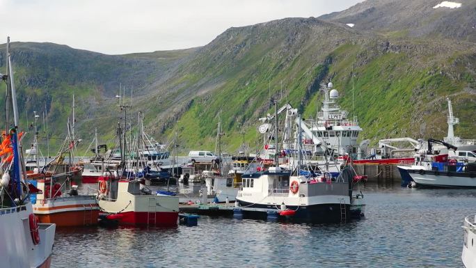 日落时分，挪威著名的历史渔村港口里的传统渔船。极性运输。在挪威钓鱼。挪威的霍宁斯瓦格市。巡游到北开普