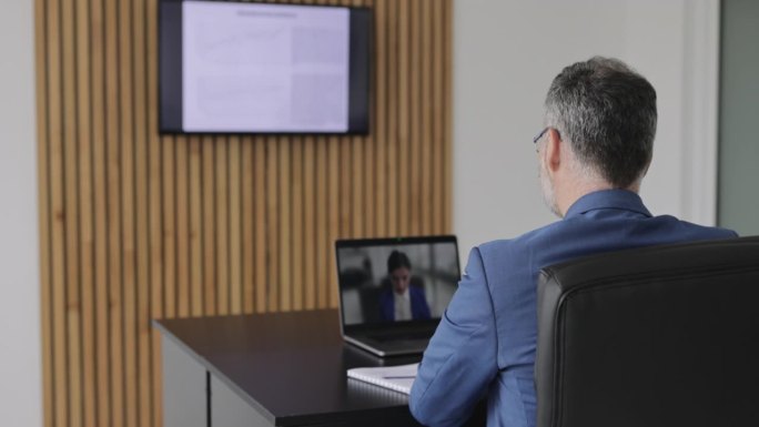 商人在办公室进行视频通话的后视图