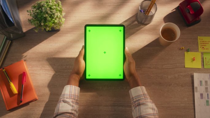 匿名办公室职员使用绿色屏幕模拟显示的平板电脑在社交媒体上发帖。男人的手拿着一个设备，与应用程序，软件