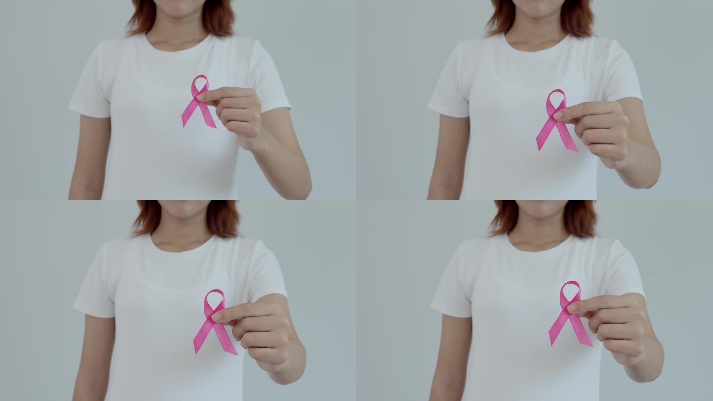 女性高举粉红丝带关注乳腺癌。女性健康检查意识。国际妇女节和世界癌症日。标志癌，象征保健，支持病人，及