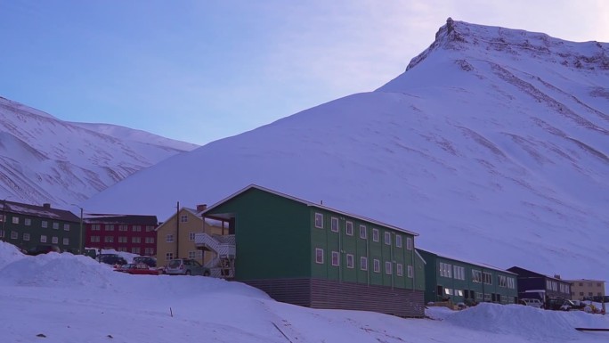 斯瓦尔巴群岛朗伊尔城冬季鸟瞰图。有五颜六色的房子，白雪皑皑的山脉，还有雪崩防护。高品质4k画面