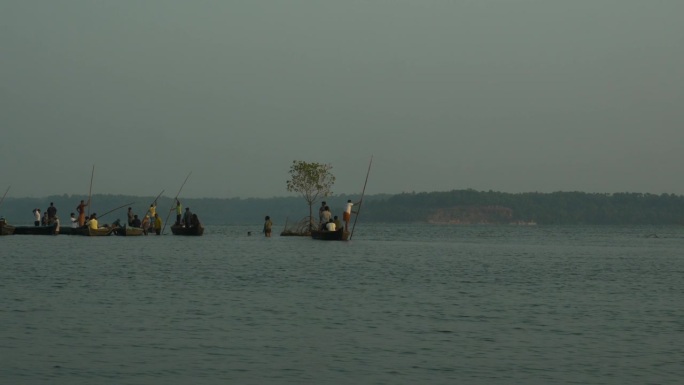 在门罗岛喀拉拉邦的丛林里，一名印度船夫驾驶着一艘木船，载着游客沿河而行。