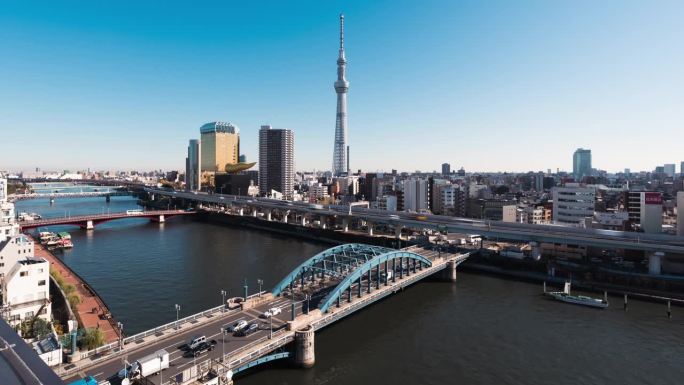 日本浅草地区的东京天空树、隅田河上的船只和小船、高速公路上的汽车交通、桥梁上的交通。亚洲旅游地标，亚