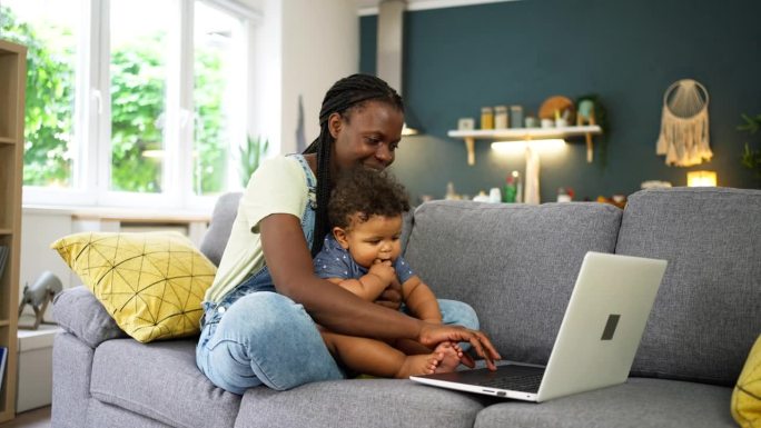 母亲和黑人男婴通过笔记本电脑进行视频通话