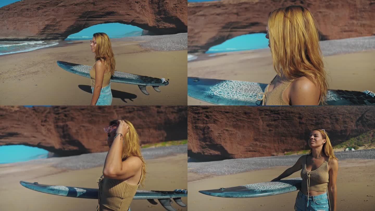金发碧眼的年轻女子腋下夹着冲浪板，看着大海，然后把太阳镜戴在头发上