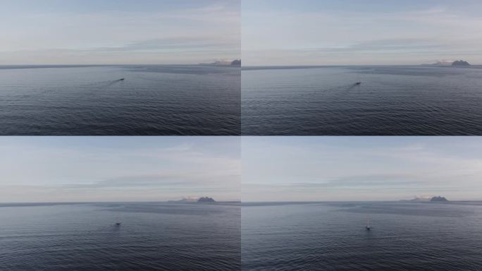 在挪威罗弗敦，一架无人机的4k镜头拍下了海洋上一艘孤独的船，周围是白雪覆盖的山脉。
