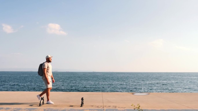 在一个阳光明媚的日子里，快乐的年轻游客独自在海边平行行走，享受着海边的美景