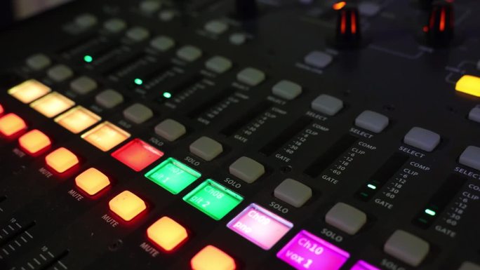 数字音频混频器特写与彩色按钮和闪烁的音量灯