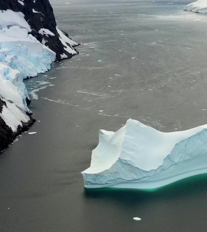 靠近雪山的垂直视频船驶向南极洲的冰山。