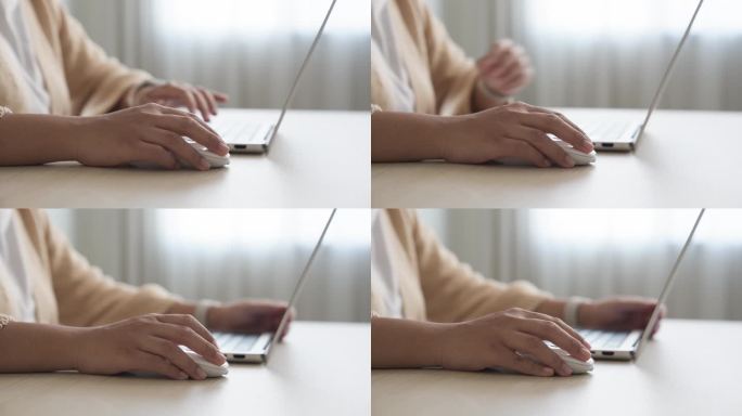 年轻女子用手点击和使用鼠标在笔记本电脑上工作