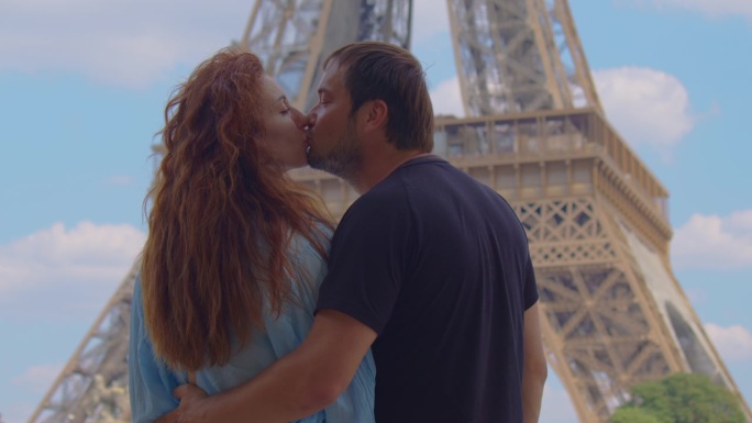 在法国首都度假的年轻男女，在埃菲尔铁塔周围散步和做活动。一对美丽的情侣在巴黎游玩