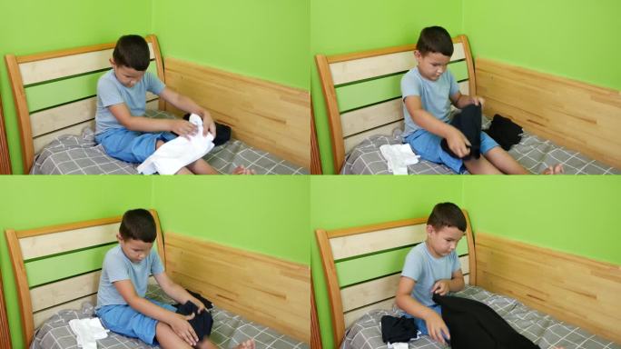 男孩小心地叠好衣服。家庭作业。洗，烫，叠衣服。