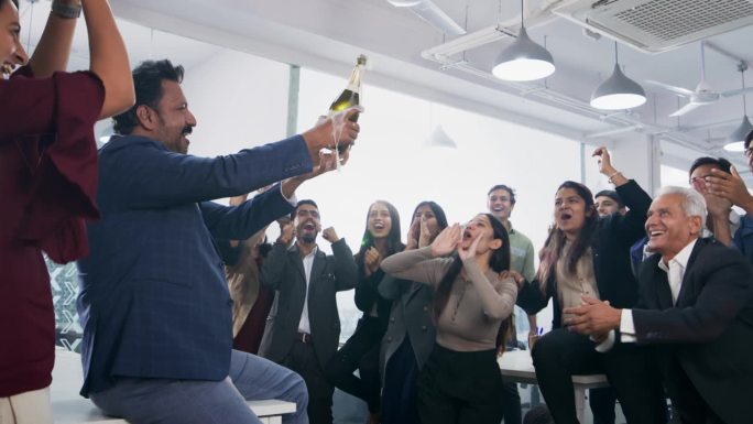 一群办公室员工一起开香槟庆祝