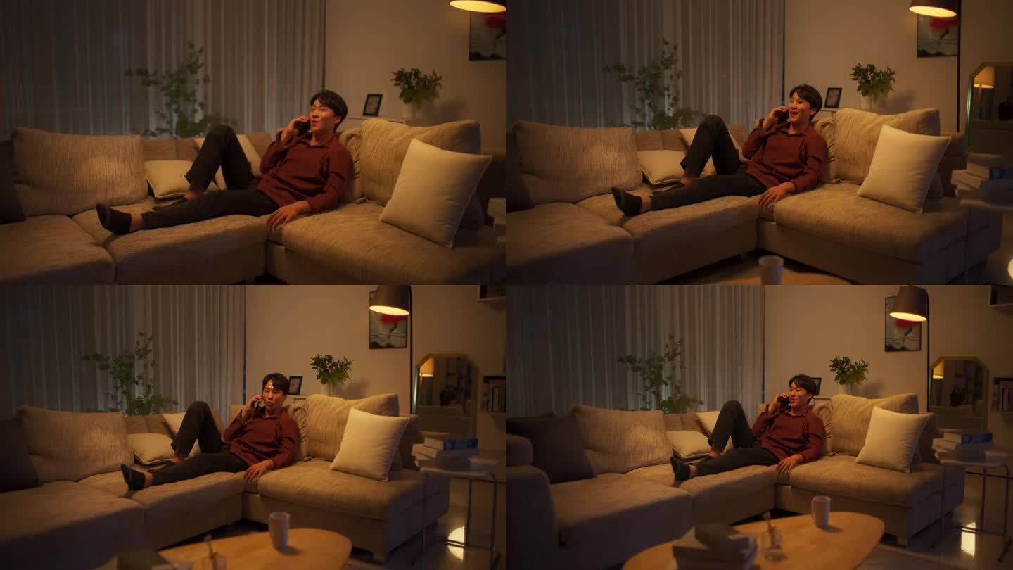 一位韩国年轻人晚上躺在舒适的沙发上，一边和同事或国际销售经理进行有意义的电话交谈，一边聊着工作