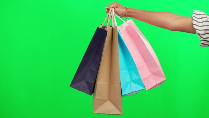 购物袋在手，零售和绿屏，产品和精品折扣隔离在工作室背景。客户与采购，人购买和商店销售与实体空间和商业
