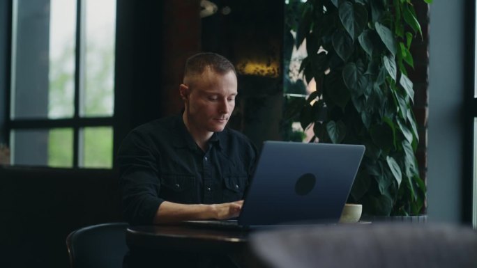 自由职业者在咖啡馆，网络开发人员的商人工作与笔记本电脑远程，在线工作