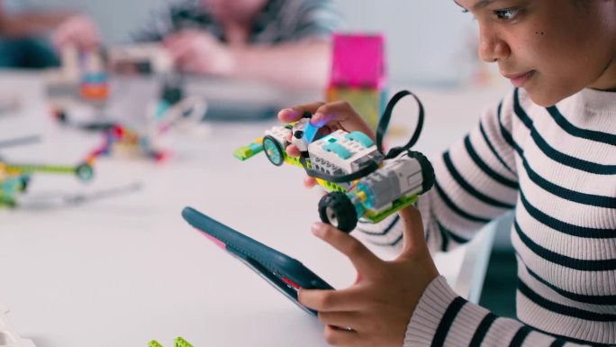 创意女孩，平板电脑和玩具车学习，教育或发展与技术在课堂上。女性儿童，儿童或青少年与小型电动汽车在建筑